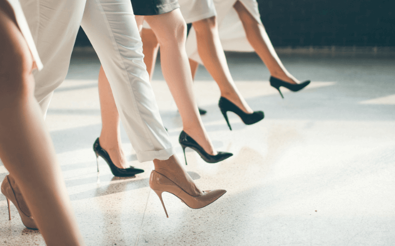 4 women walking in a line with heels